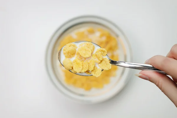 Colher cheia de flocos de milho na mão close-up conceito de café da manhã — Fotografia de Stock