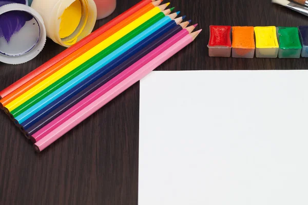 Folha de papel em branco com lápis e tintas coloridas — Fotografia de Stock