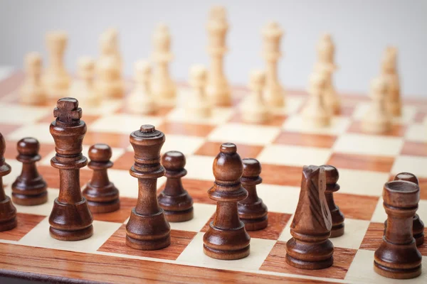 Placa de xadrez com figuras sobre fundo cinza — Fotografia de Stock