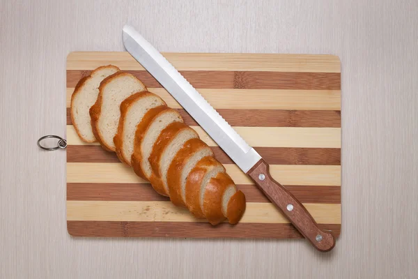 Szeletelt kenyér a kenyérvágódeszka, és kés — Stock Fotó