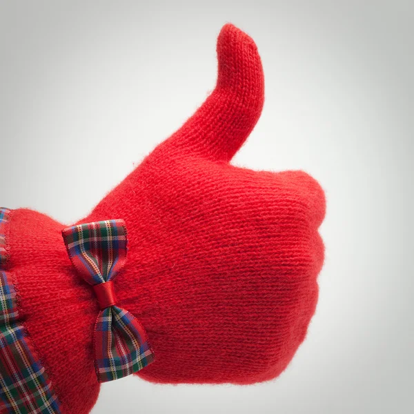 Большой палец в красной перчатке на сером фоне — стоковое фото