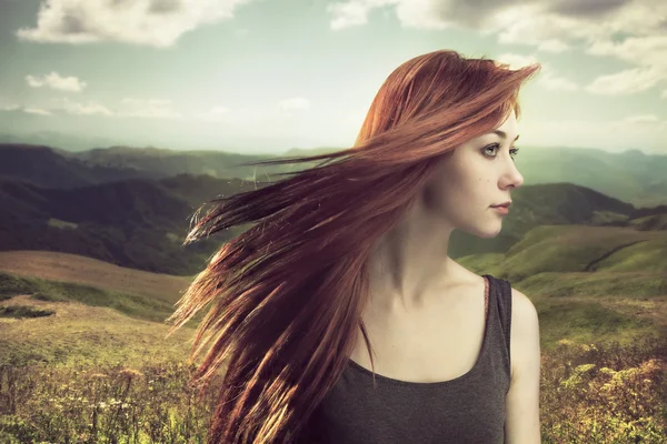 Beautiful girl upland with hair blown by wind — Stock Photo, Image