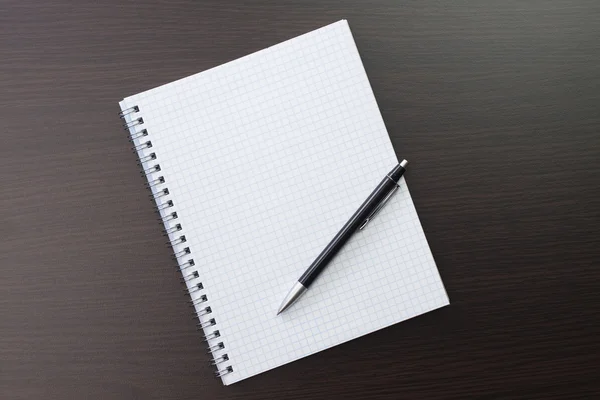 Blanco notitieboekje en pen op tafel — Stockfoto