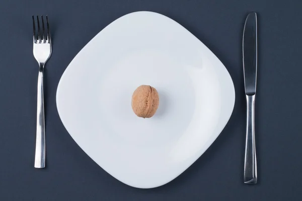 Nogal circasiano sobre plato blanco con cuchillo y tenedor —  Fotos de Stock
