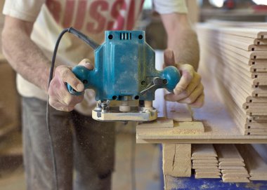 Home improvement - handyman sanding wooden floor in workshop clipart