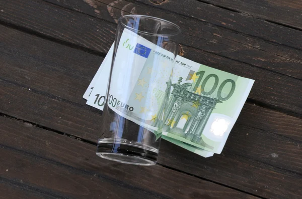 Prázdné sklo a sto EUR bankovky — Stock fotografie