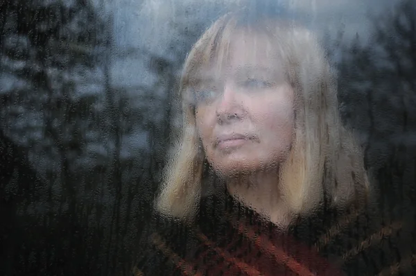 Portret van vrouw door het raam — Stockfoto