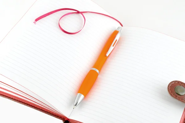 Notebook a oranžové pero — Stock fotografie