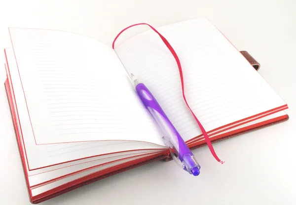 Блокнот і фіолетова ручка — стокове фото