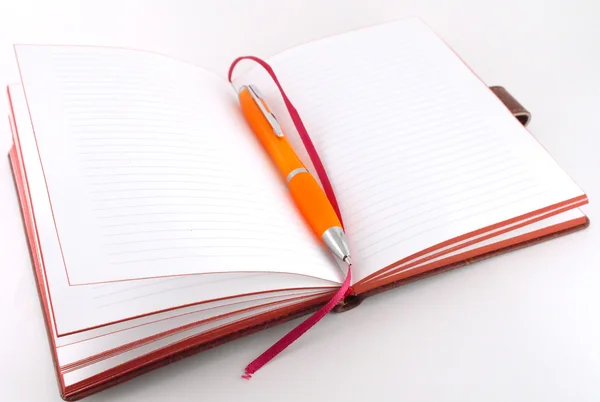 Σημειωματάριο και πορτοκαλί πένα — Φωτογραφία Αρχείου