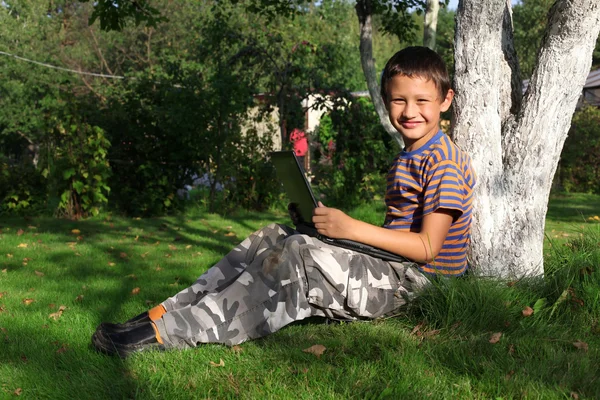 屋外のラップトップ上の少年 — ストック写真