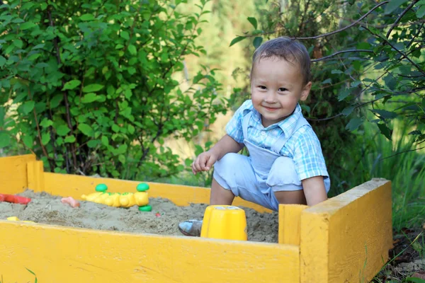 Bebé juega con juguetes en caja de arena —  Fotos de Stock