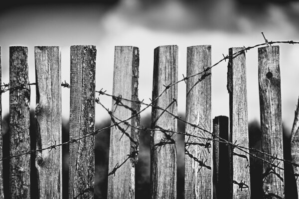 Old wooden fence with rusted barbed wire