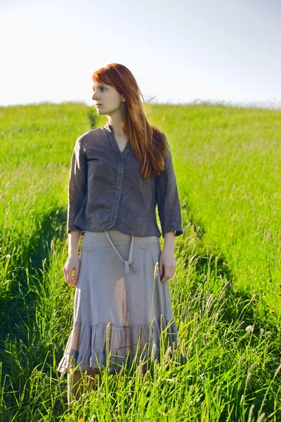 Sad redhead woman in grass — Stock Photo, Image