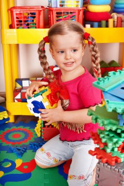 Child with puzzle, block and construction set in play room. clipart