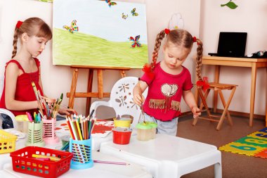 Group of children with colour pencil in play room. clipart