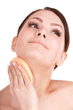 Young woman washing her face by sponge. clipart