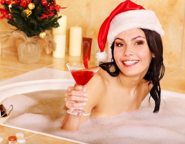 Woman in santa hat relax in bath. clipart