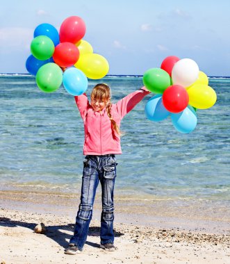 Balonlar ile plajda oynayan çocuk