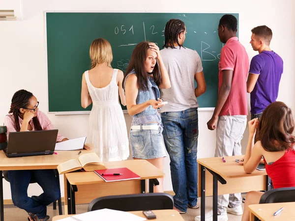 Estudante em sala de aula perto de quadro negro . — Fotografia de Stock