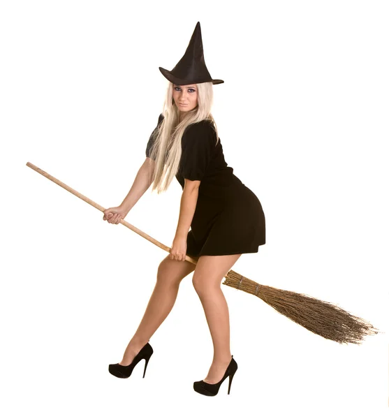 Хэллоуинская блондинка в черном платье и шляпе на метле . — стоковое фото