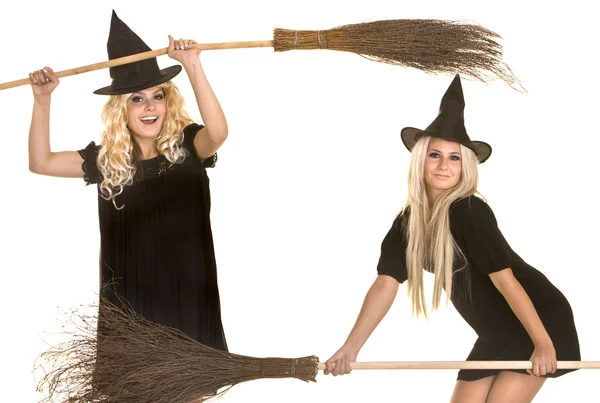 Dos brujas de Halloween en vestido negro y sombrero en pancarta de escoba . —  Fotos de Stock