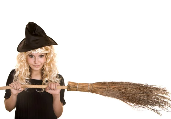 Halloween häxa blond i svart klänning och hatt med kvast. — Stockfoto