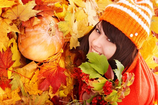 Meisje in herfst oranje bladeren met pompoen. — Stockfoto