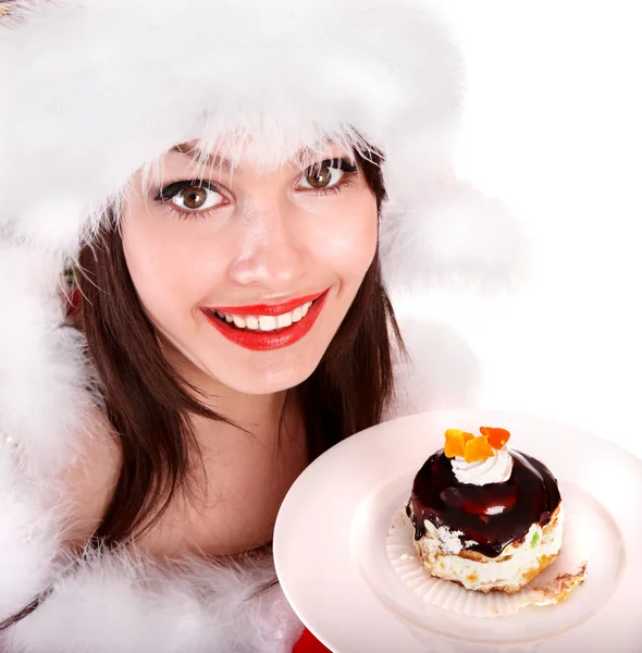 Χριστούγεννα κορίτσι στην το καπέλο santa φάω κέικ στο πιάτο. — Φωτογραφία Αρχείου