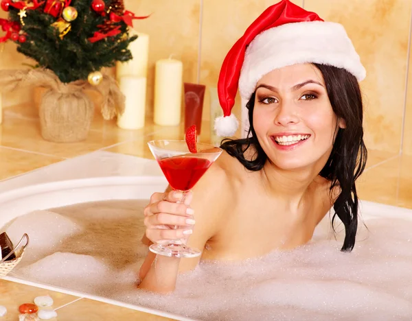 Γυναίκα με καπέλο santa χαλαρώσετε στην μπανιέρα. — Φωτογραφία Αρχείου