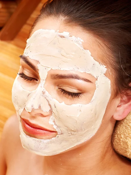 Jovem mulher com máscara facial de barro . — Fotografia de Stock