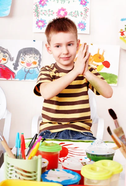 Bambino con foto e pennello in sala giochi . — Foto Stock