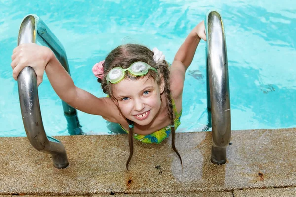 Meisje in de sport brillen bladeren zwembad. — Stockfoto