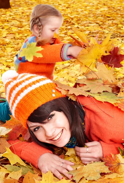 Glückliche Familie mit Kind auf herbstorangefarbenen Blättern. — Stockfoto
