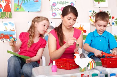 Child with teacher in play room. clipart