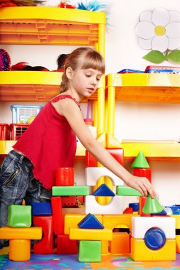 Child with block and construction set in play room. Preschool. clipart