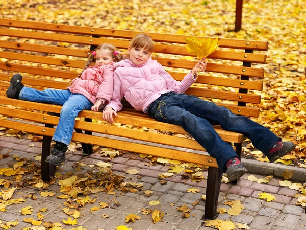 Kid in autumn orange leaves.