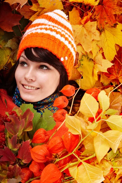 Girl in autumn orange hat on leaf group with flower. — Stock Photo, Image