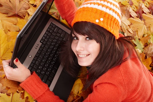 Girl in autumn orange leaves with laptop. — Stock Photo, Image