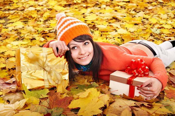 Flicka i höst utomhus håller presentförpackning. — Stockfoto