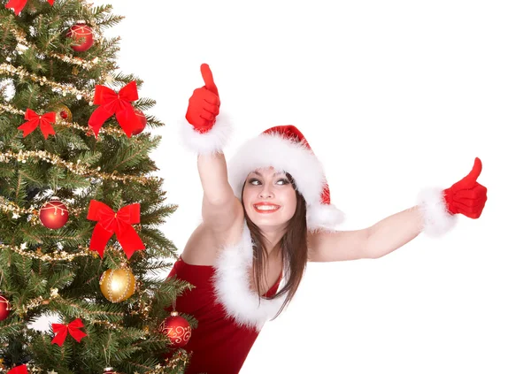 圣诞女孩在圣诞老人的帽子和杉木树中用两个拇指向上. — 图库照片