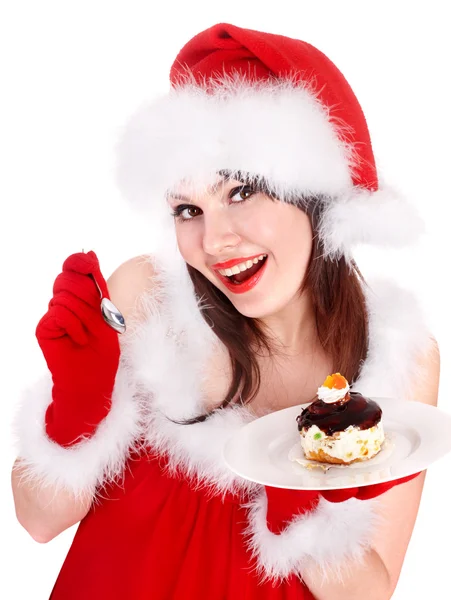 Noel Noel Baba şapkalı kız yemek pasta plaka üzerinde. — Stok fotoğraf