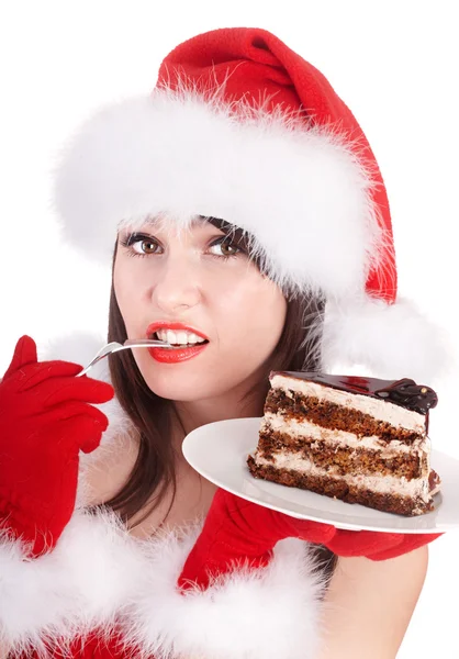 Weihnachtsmädchen mit Weihnachtsmütze essen Kuchen auf Teller. — Stockfoto