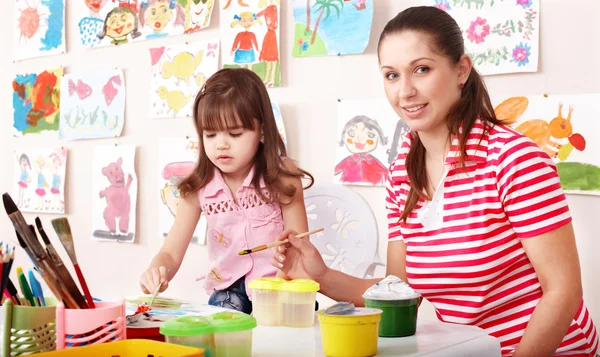 Barn målar med lärare i förskolan. — Stockfoto