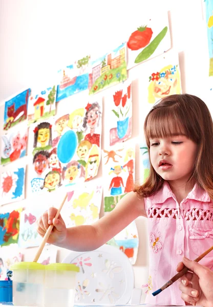 Criança com imagem e escova na sala de jogos . — Fotografia de Stock