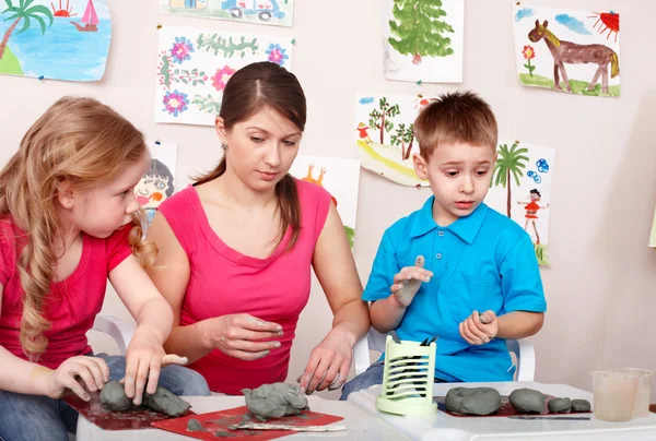 Children mould with teacher from clay. — Stock Photo, Image