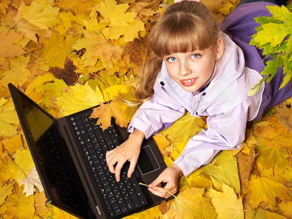 Kind im Herbst orange Blätter mit Laptop. — Stockfoto