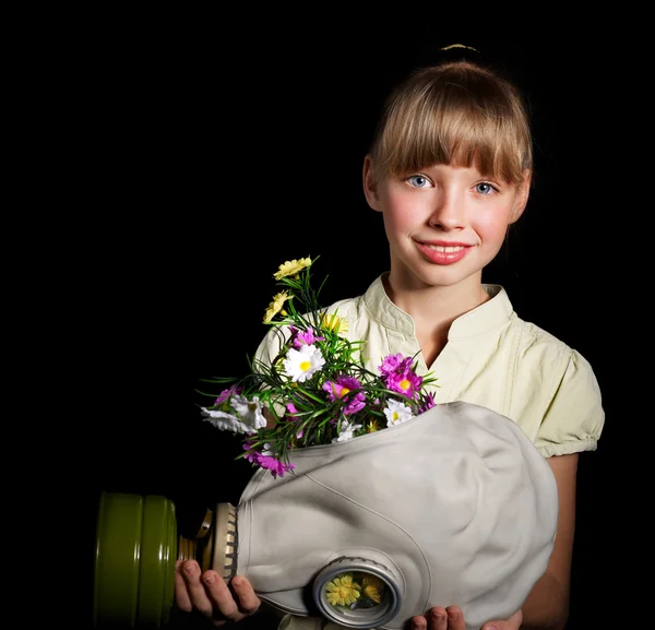 Ребенок держит цветы и противогаз  . — стоковое фото
