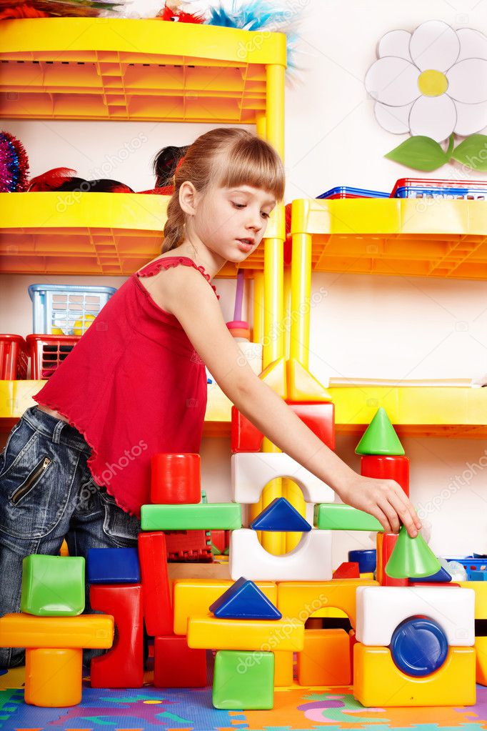 Child with block and construction set in play room. Preschool.