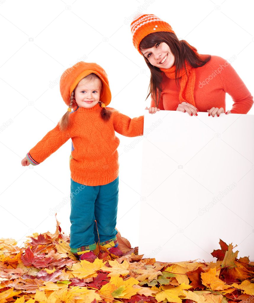 Family with child on autumn leaves holding banner.